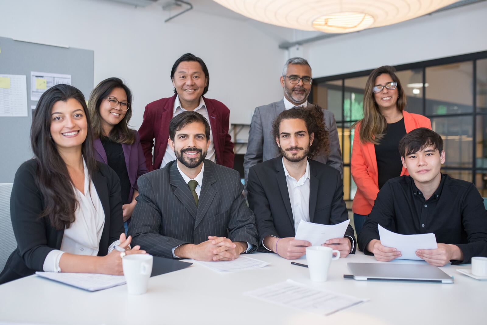 Global Business Consulting and Training 119 Diverse team of professionals smiling around a meeting table